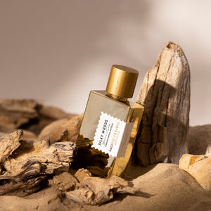 Goldfield & Banks - Botanical Series - Silky Woods Elixir Parfumflakon in goldfarbenem Design zwischen Holzstücken und Sand