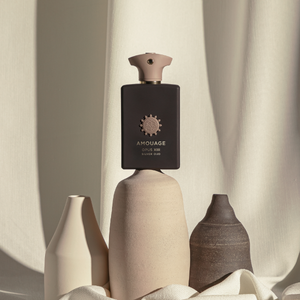 Amouage - Library Collection - Opus XIII - Silver Oud Flakon in mattschwarzem Design mit beigem Verschluss vor hellem Stoffhintergrund