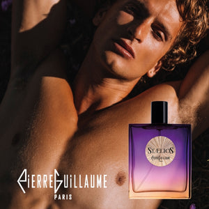 Pierre Guillaume - Beyond Collection - Stælios Parfumflakon mit intensiv violett-orangem Farbverlauf neben männlichem Modell