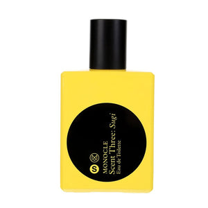 Comme des Garçons - Monocle - Scent Three: Sugi Parfumflakon in leuchtendem Gelb mit schwarzem Rundetikett und Verschluss