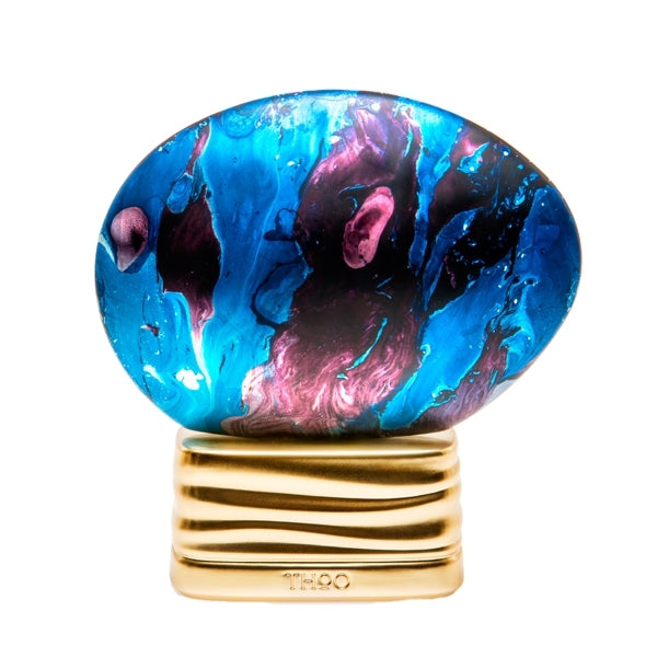 THoO - The Time Flakon mit blau-violett marmorierter Oberfläche auf welligem goldfarbenem Sockel vor weißem Hintergrund