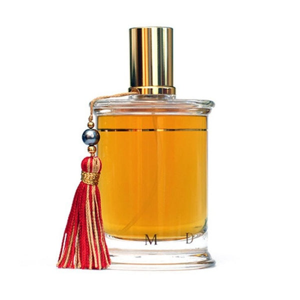 Parfums MDCI Paris - Ambre Topkapi Flakon mit goldenem Verschluss und rotem Quastenanhänger vor weißem Hintergrund