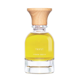 Hiram Green - Tryst Parfumflakon mit klarem Glas und Holzdeckel, gefüllt mit goldenem Öl vor weißem Hintergrund