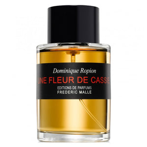 Frédéric Malle - Une Fleur de Cassie Parfumflakon mit bernsteinfarbener Flüssigkeit und schwarzem Verschluss vor weißem Hintergrund