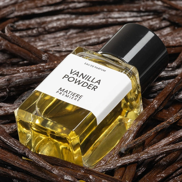 Matière Première - Vanilla Powder Eau de Parfum Flakon auf Vanilleschoten liegend vor dunklem Hintergrund