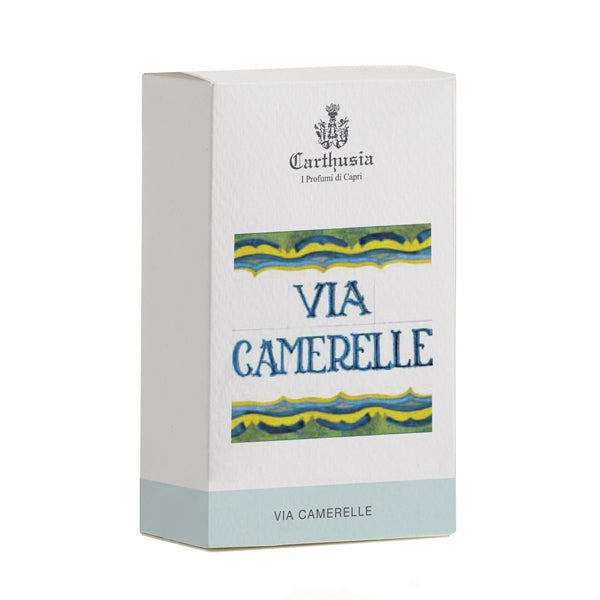 Carthusia - Via Camerelle Verpackung mit blau-gelben Verzierungen auf weißem Karton und grauem Boden sichtbar