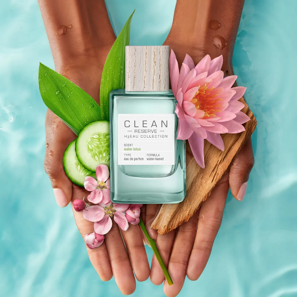 Clean Perfume - H2Eau Water Lotus Flakon mit Holzverschluss und Lotusblüte auf Händen vor Wasserhintergrund