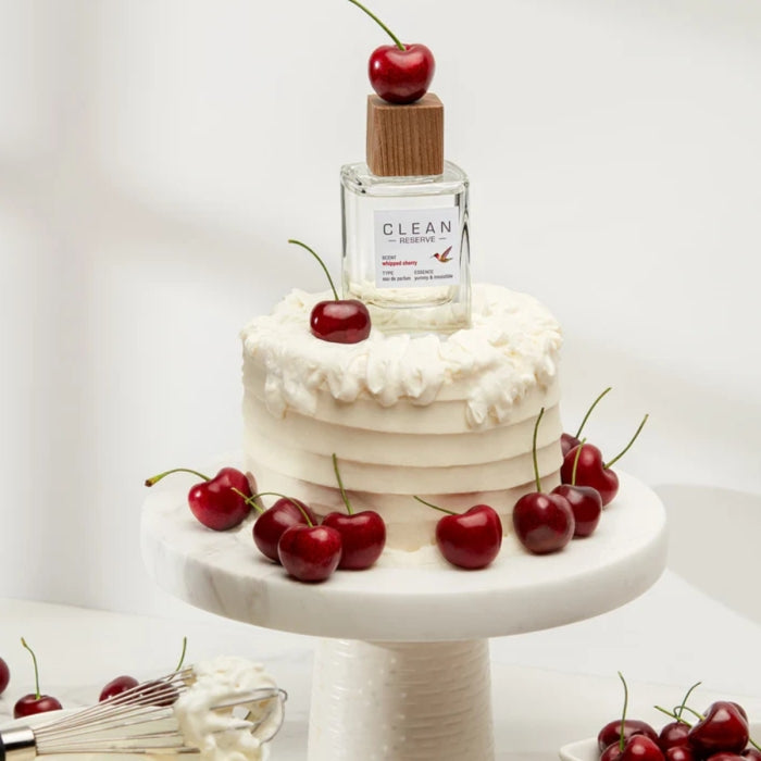 Clean Perfume - Reserve - Whipped Cherry Flakon auf weißer Torte mit frischen Kirschen dekorativ arrangiert
