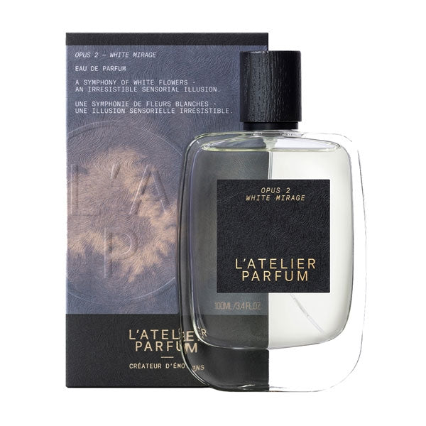 L'Atelier Parfum - Opus 2 - White Mirage transparenter Flakon mit schwarzem Etikett und Verpackung vor weißem Hintergrund