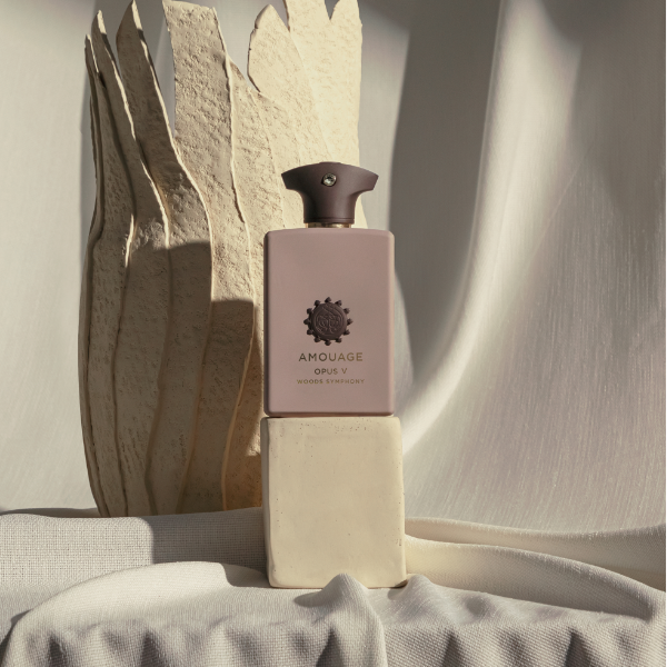 Amouage - Library Collection - Opus V - Woody Symphony Flakon in mattem Beige vor skulpturalem Hintergrund
