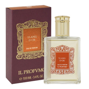 Il Profumo - Ylang d'Or eleganter Flakon mit goldfarbenem Verschluss und verziertem Etikett neben tiefroter Verpackung