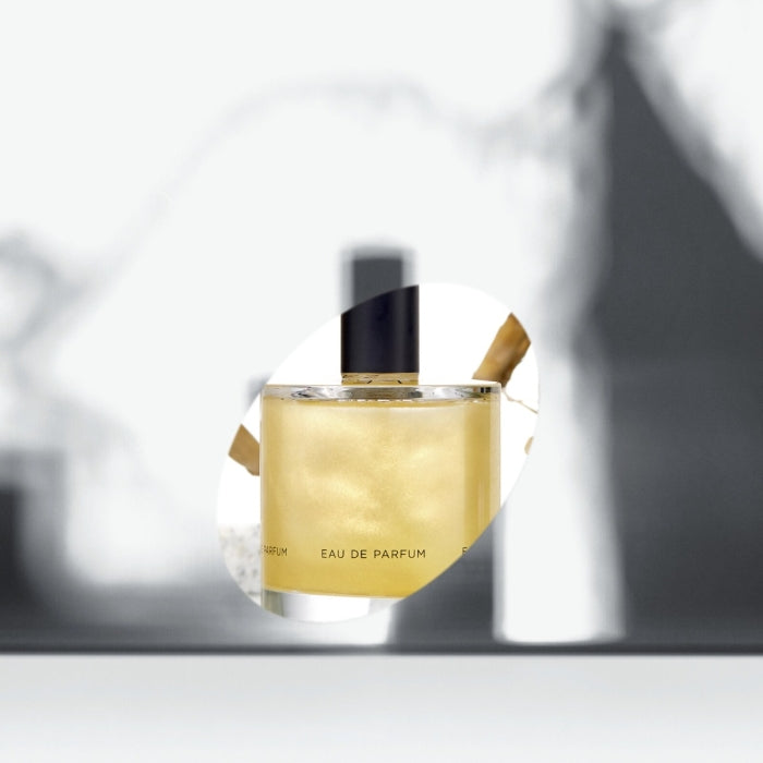 Zarkoperfume - Cloud Collection No.4 Parfumflakon mit goldschimmerndem Inhalt und schwarzem Verschluss vor unscharfem Hintergrund