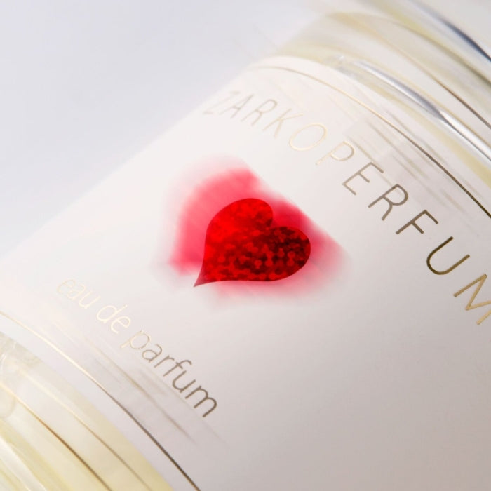 Zarkoperfume - Sending Love Parfumflakon mit rotem Herzsymbol und goldener Schrift auf hellem Hintergrund in Nahaufnahme